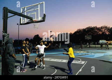 UK Weather, Clapham, London, 15. Juni 2023: An einem leichten Sommerabend nach einem heißen Tag nutzen Basketballspieler die Plätze mit Flutlicht auf Clapham Common, um etwas Übung zu bekommen. Kredit: Anna Watson/Alamy Live News Stockfoto