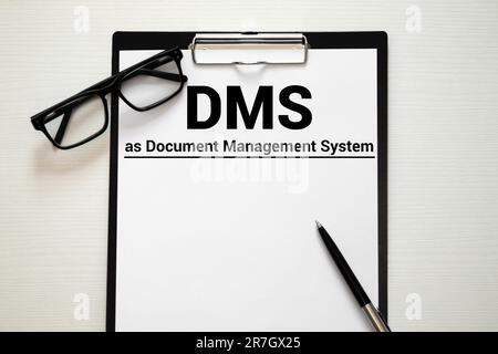 Weißer Bürotisch mit leerem Blatt, Text DMS Document Management System, Tastatur und Hammer, Draufsicht. Stockfoto