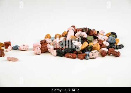 Farbenfrohe Schokoladensteine auf weißem Hintergrund Stockfoto