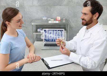 Der Arzt zeigt das Patientenschulungsmodell des Zahnimplantats in der Klinik Stockfoto