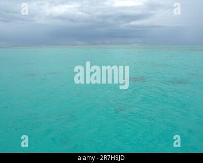 Moorea, Französisch-Polynesien: Wolken der dunklen Regenzeit über der blauen Lagune nähern sich dem tropischen Sturm, Stockfoto