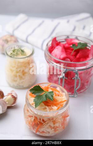 Köstliches Sauerkraut, nach verschiedenen Rezepten auf weißem Tisch zubereitet, Nahaufnahme Stockfoto