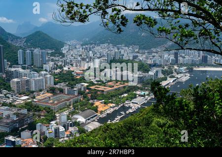 Luftaufnahme der dichten Stadtteile Urca und Botafogo, von der Aussichtsplattform auf dem Gipfel des Urca-Hügels unter dem sonnigen blauen Himmel am Sommernachmittag. Stockfoto