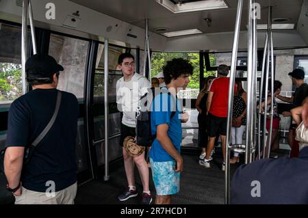 Innenansicht der Passagierkabine der Zuckerhut-Seilbahn, während Passagiere einsteigen und auf die Abfahrt in Richtung der Zuckerhut-Bergstation warten. Stockfoto