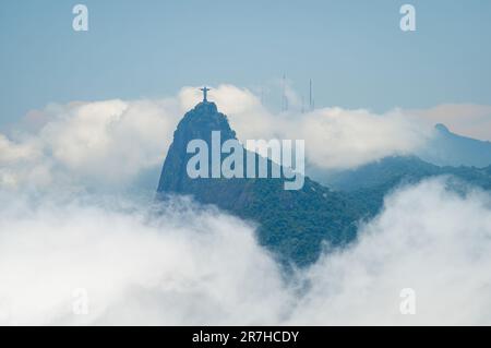 Weiter Blick auf den Corcovado, Ort der Christusstatue, umgeben von dicken Wolken unter sonnigen Wolken am Sommernachmittag. Stockfoto