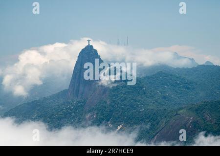 Weiter Blick auf den Corcovado (Bucklige), Heimat der Christusstatue mit schweren Wolken in der Nähe unter dem sonnigen blauen Himmel am Sommernachmittag. Stockfoto