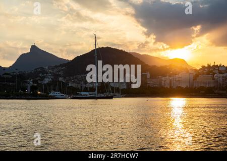 Blick auf den goldenen Sonnenuntergang von der Almirante Silvio de Noronha Avenue, in der Nähe des Flughafens Santos Dumont der Küste des Viertels Gloria unter dem späten WolkenHimmel im Sommer. Stockfoto