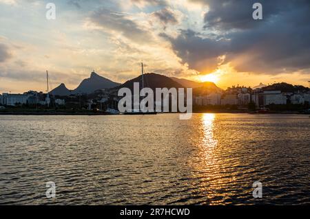 Breiter Blick auf den Sonnenuntergang, wie Sie ihn von der Almirante Silvio de Noronha Avenue, in der Nähe des Flughafens Santos Dumont der Küste des Gloria Bezirks im Sommer am späten Nachmittag sehen. Stockfoto