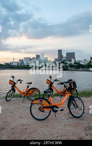 Einige Itau Leihfahrräder parken am Ende des Santos Dumont Rock Pier (Pier de Pedra) unbefestigter Pfad im Centro Viertel unter dem Sommer am späten Nachmittag Himmel. Stockfoto