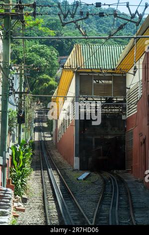 Blick auf die Corcovado Rack Railway Gleise und das Wartungsdepot auf der rechten Seite neben dem Bahnhof Cosme Velho unter dem sonnigen blauen Himmel. Stockfoto