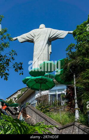 Die Rückseite der Christusstatue sah von der Treppe in der Nähe eines Restaurants des Corcovado Berges unter dem sonnigen blauen Himmel am Sommernachmittag. Stockfoto