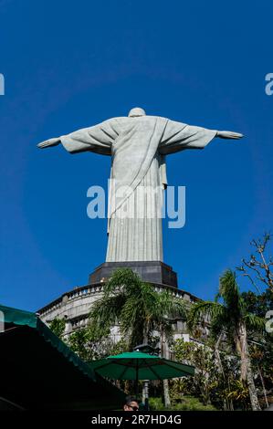 Die volle Rückseite der Christusstatue wurde von der Treppe des Corcovado im Viertel Santa Teresa unter dem sonnigen blauen Himmel gesehen. Stockfoto