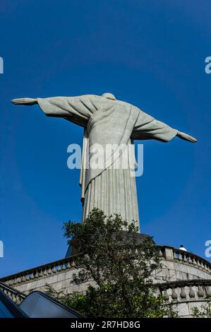 Die Rückseite der Christus-Erlöser-Statue sah vom Boden der Ausstiegsrampen des Corcovado Berggipfels unter dem sonnigen, klaren blauen Himmel. Stockfoto