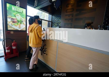 HO-CHI-MINH-STADT, VIETNAM - CA. MÄRZ 2023: Undefinierte Frauen im McCafe in McDonald's Fast Food Restaurant. Stockfoto