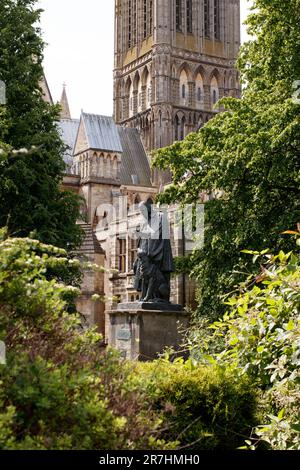 Die Statue von Alfred Lord Tennyson auf der Lincoln Cathedral Green, eine denkmalgeschützte Statue der Kategorie II, aus dem Jahr 1905, von G F Watts, RA, restauriert im Jahr 1970. Es ist eine bronzefarbene Figur mit einem Hund, auf einem Aschenbecher mit Plaketten im Osten und Westen. Stockfoto