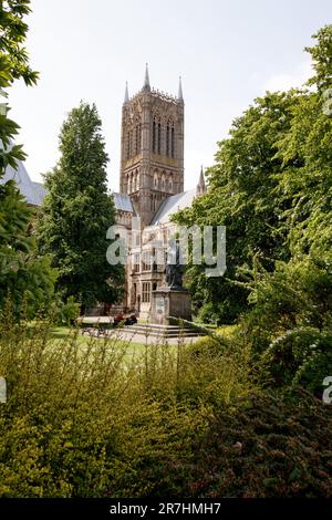 Die Statue von Alfred Lord Tennyson auf der Lincoln Cathedral Green, eine denkmalgeschützte Statue der Kategorie II, aus dem Jahr 1905, von G F Watts, RA, restauriert im Jahr 1970. Es ist eine bronzefarbene Figur mit einem Hund, auf einem Aschenbecher mit Plaketten im Osten und Westen. Stockfoto