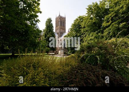 Die Statue von Alfred Lord Tennyson auf der Lincoln Cathedral Green, eine denkmalgeschützte Statue der Kategorie II, aus dem Jahr 1905, von G F Watts, RA, restauriert im Jahr 1970. Es ist eine bronzefarbene Figur mit einem Hund, auf einem Aschenbecher mit Plaketten im Osten und Westen. Stockfoto