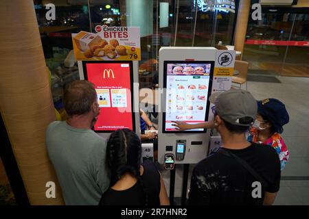 PATTAYA, THAILAND - CIRCA APRIL 2023: Gäste nutzen Selbstbedienungskioske, um Bestellungen in McDonald's Fast Food Restaurant in Pattaya aufzugeben. Stockfoto