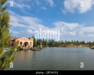 Malerischer Blick auf das Haus neben dem See und dem blauen Himmel. Stockfoto