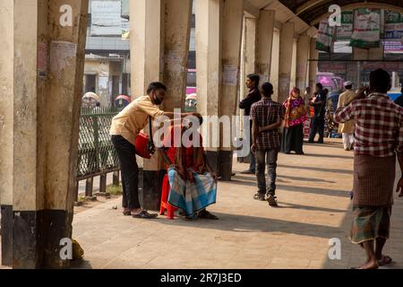 Ein Mann bekommt am Bahnhof Kamlapur in Dhaka, Bangladesch, die Ohren von einem Straßenohrreiniger sauber gemacht Stockfoto