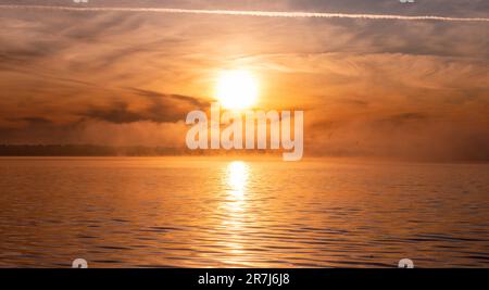 Rerik, Deutschland. 31. Mai 2023. Die Sonne geht über der Salzlagune auf, bedeckt mit Nebel. In der Salzhaff werden Ostseekrabben und Knoblauch bis Mitte Juni gefangen. Kredit: Jens Büttner/dpa/Alamy Live News Stockfoto