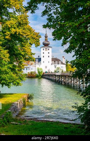 Schloss Ort in der Nähe des Traunsees, Österreich. Blick auf das antike Schloss mit langer Brücke über den See. Berühmtes Touristenziel. Stockfoto
