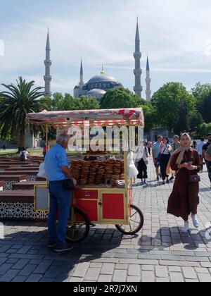 Roter Wagen mit türkischen Simits aka türkische Bagels mit der Sultan-Ahmed-Moschee (aka Blaue Moschee) dahinter. Istanbul, Türkei. Stockfoto