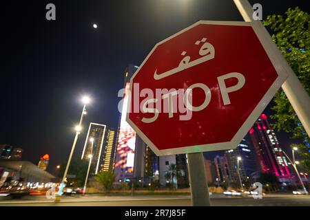 DOHA, KATAR - CIRCA MÄRZ 2023: Nahaufnahme des Straßenschilds „Stop Street“, das in der Nacht in Doha gesehen wurde. Stockfoto