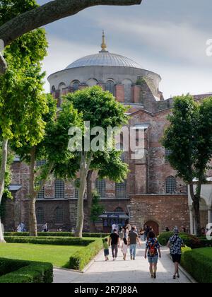 Besucher in den Gärten des Topkapi-Palastkomplexes mit der Hagia Irene-Kirche dahinter. Die älteste bekannte Kirche in Istanbul, Türkei Stockfoto