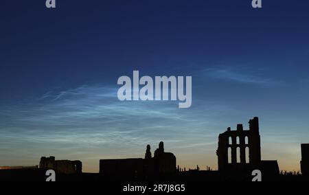 Zwischen 1,15 und 2 Uhr bilden sich im Tynemouth Priory in North Tyneside nächtliche Wolken. Nächtliche Wolken sind extrem selten sehr hohe Wolken, die am Nachthimmel zu sehen sind, in der Regel an klaren Sommernächten, Eine Stunde nach Sonnenuntergang und eine Stunde vor Sonnenaufgang, wenn die Sonne zwischen -6 und -10 Grad steht. Sie werden etwa zur gleichen Zeit wie die hellsten Sterne sichtbar und sind meist bläulich oder silberfarben. Foto: Freitag, 16. Juni 2023. Stockfoto