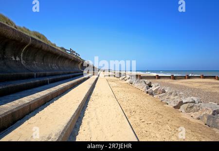 Ein Blick nach Westen an der Meereswand, der die verschiedenen Arten der Meeresabwehr an der Ostnorfolkküste bei Cart Gap, Happisburgh, Norfolk, England, Großbritannien zeigt. Stockfoto