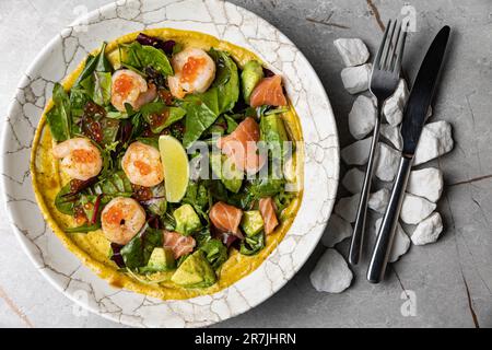 Eine köstliche Schüssel mit einem gesunden bunten Salat mit frischem Salat, Garnelen und anderem Gemüse Stockfoto