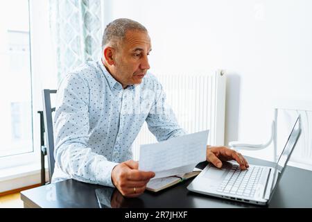 Porträt-Mann mittleren Alters, der Notizen in Notizbuch macht Stockfoto