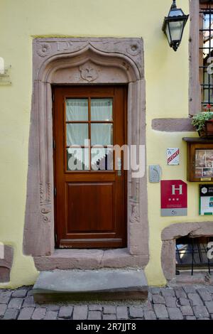 Historische Tür mit Steinarbeiten in Riquewihr und Elsass Stockfoto