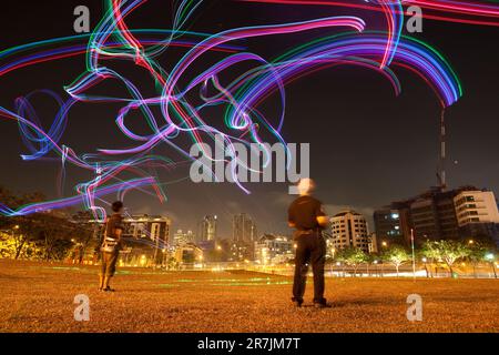 Mitglieder des Singapore Night Flyer Kite Clubs erleuchten den Abendhimmel mit ferngesteuerten Drachen, die mit bunten LED-Lichtern geschmückt sind. Stockfoto