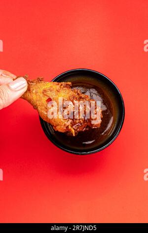 Bild einer Schüssel mit gebratenen Hähnchenflügeln, bespritzt mit einer würzigen, süßen Büffelsauce Stockfoto