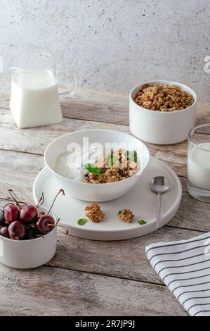 Müsli in einer Schüssel mit Joghurt und frischen Kirschen Stockfoto