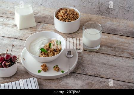 Müsli in einer Schüssel mit Joghurt und frischen Kirschen Stockfoto
