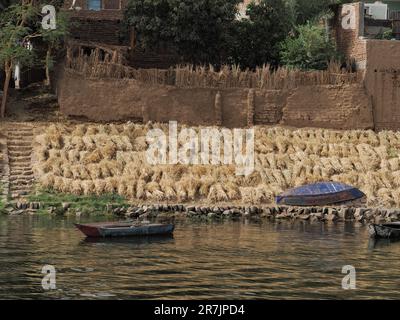 Riverside Bank mit Booten und Weizenfeldern, die die Sonne trocknen Stockfoto