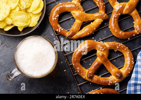Frisch gebackene hausgemachte Brezeln und Bier vom Fass. Flach liegend Stockfoto
