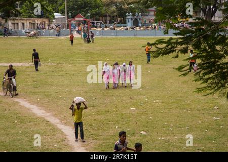 Ein bangladeschisches Schulmädchen, das auf einem Spielplatz in Gghior, Manikganj, Bangladesch spaziert. Stockfoto