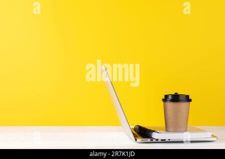 Laptop, Notizblock und Kaffeetasse. Computer auf dem Schreibtisch mit Platz für Ihre SMS Stockfoto
