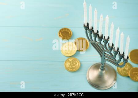 Frohes Chanukka. Chanukka altes Menorah vor dem Hintergrund der israelischen Flagge mit Sonnenlicht oder Bokeh auf weißem Holzhintergrund. Religionsbild der juden Stockfoto