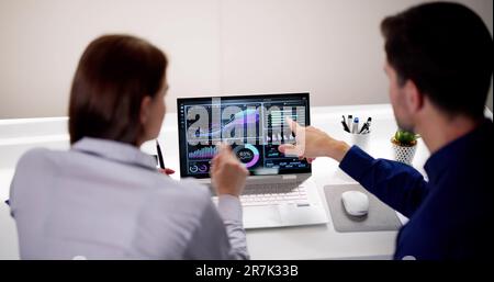 Zwei Analytiker, die KPI-Dashboard auf einem Laptop verwenden Stockfoto