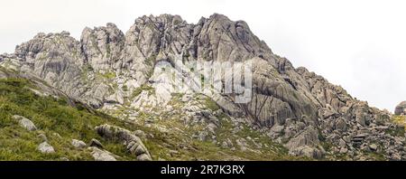 Malerische, zerklüftete Granitberge der Serra da Mantiqueira (Mantiqueira Gebirgskette) mit grasbedeckten Teilen vor hellem Hintergrund, obere Itatiaia, Stockfoto