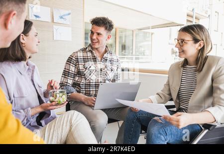Junge Geschäftsleute, die sich im Büro treffen und eine Frau im Rollstuhl sitzen Stockfoto