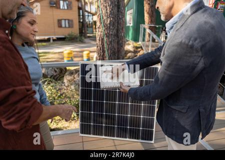 Berater erklärt den Hauseigentümern die solarbetriebene Station Stockfoto