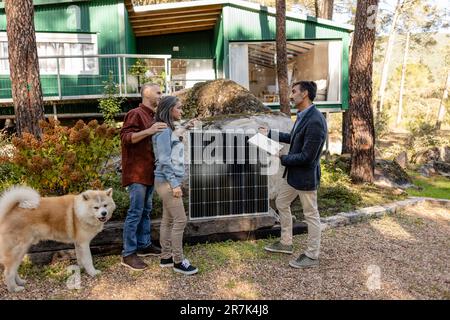 Berater erklärt den Hauseigentümern die solarbetriebene Station Stockfoto