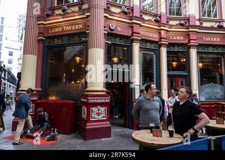 Stadtarbeiter genießen am 25. Mai 2023 einen Drink auf dem Leadenhall Market in der City of London in London, Großbritannien. Der Markt in der Gracechurch Street stammt aus dem 14. Jahrhundert. Es gibt Käsemonger, Metzger und Floristen. Ursprünglich war es ein Fleisch-, Wild- und Geflügelmarkt, der im Zentrum des römischen London stand. 1881 entworfen von Sir Horace Jones. Stockfoto