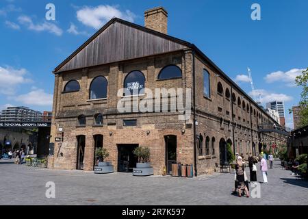 Gewerbegebiet von Coal Drops Yard in Kings Cross am 24. Mai 2023 in London, Vereinigtes Königreich. Kings Cross Central ist ein Multi-Milliarden Pfund Mixed-Use-Entwicklungsgebiet auf einem Gelände, das im Besitz und unter der Kontrolle der Kings Cross Central Limited Partnership steht und etwa 67 Hektar ehemaliges Eisenbahngelände umfasst. King’s Cross ist eine der größten und transformativen Neuentwicklungen, die in London in jüngster Zeit zu sehen waren und eine ehemalige Industriestätte in ein erneuertes und lebendiges Gebiet mit Plätzen, Parks, Häusern, Geschäften, Büros, Galerien, Bars, Restaurants und Bildungsgebäude. Stockfoto